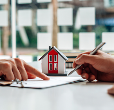 Signing real estate contract with model house